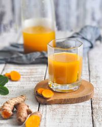 Close-up of juice and ginger on table