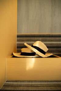 Close-up of hat on table against wall