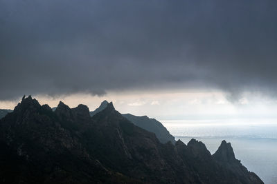 Peaks of anaga mountains with ocean view and dramatic dark clouds above.
