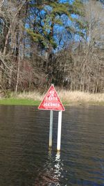 Lifeguard hut by trees against sky
