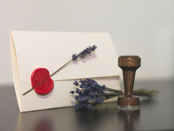 Close-up of envelope and lavender flowers on table