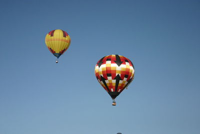 Low angle view of hot air balloon against clear blue sky