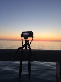 View of camera on sea against sky during sunset