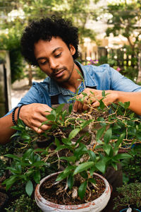 Portrait of young man holding potted plant