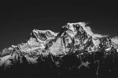 Low angle view of snowcapped mountains against sky