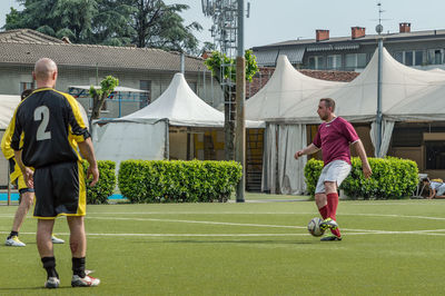 Full length rear view of man playing soccer