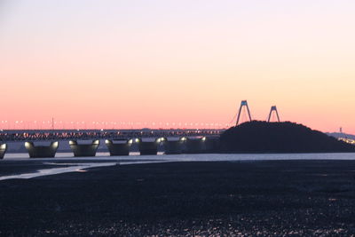 Bridge over river against clear sky during sunset