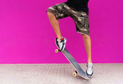 Low section of man with pink umbrella