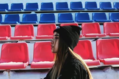 Full length of young woman sitting on seat