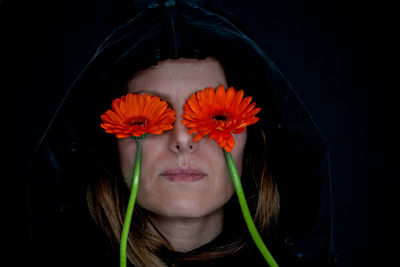 Portrait of woman wearing hat against black background
