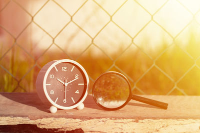 Close-up of clock on table against wall