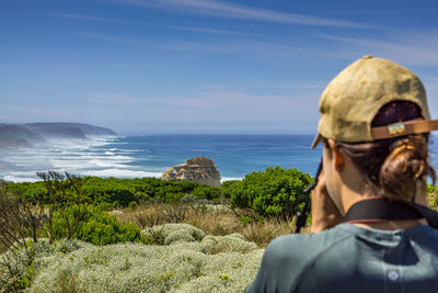 Rear view of man looking at sea against sky