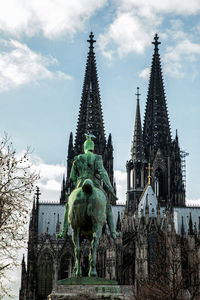 Low angle view of statue against buildings