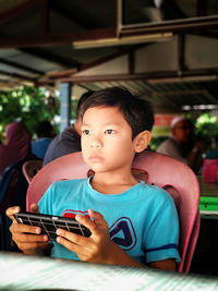 Portrait of boy holding mobile phone