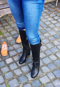 Low section of people standing on cobblestone