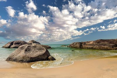 Scenic view of rocks on beach against sky