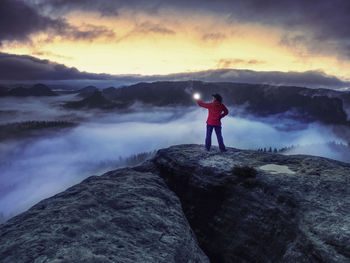 Woman bring light on mountain to give light to whole world in darkess. silhouette of woman in night