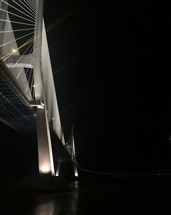 Low angle view of illuminated bridge against sky at night