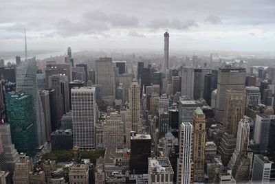 Aerial view of buildings in city against sky