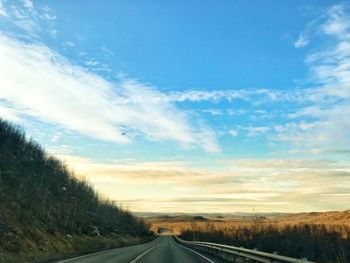 Road by landscape against sky