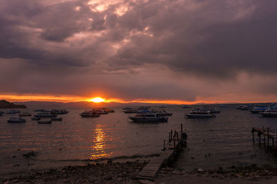 Scenic view of sea against dramatic sky during sunset