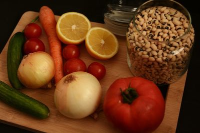 Close-up of knife and vegetables with black-eyed pea on cutting board