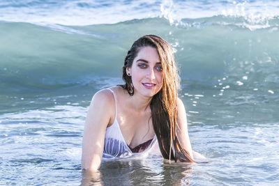 Portrait of smiling young woman against sea