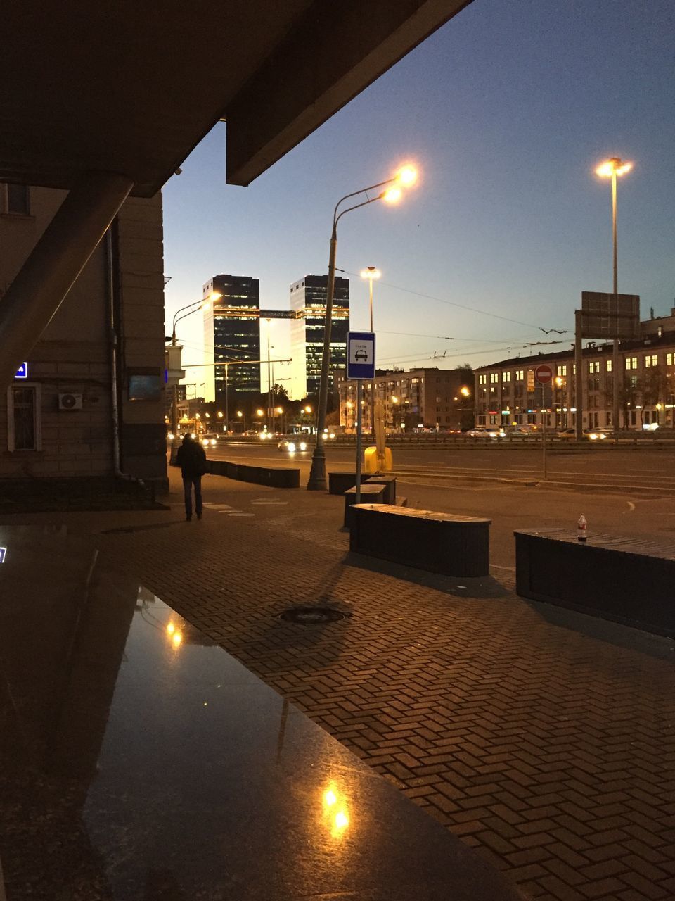 ILLUMINATED STREET LIGHTS BY BUILDINGS AGAINST SKY AT NIGHT