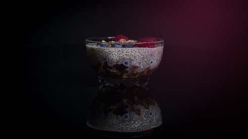 Close-up of fruits in bowl against black background