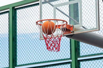 Low angle view of ball in basketball hoop