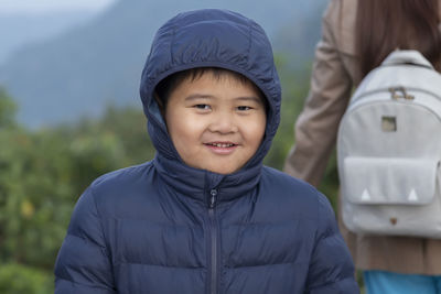 Portrait of smiling boy standing outdoors during winter