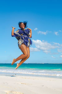 Full length of woman jumping on beach