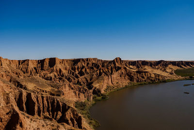 Barrancas de burujon by sea against clear blue sky