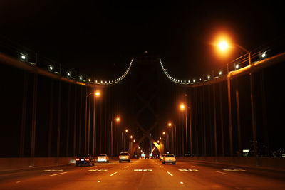 Illuminated bridge in city at night