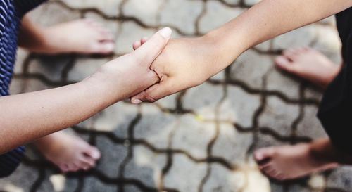 Midsection of mother holding hands