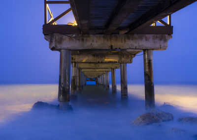 Bridge over sea against sky during sunset