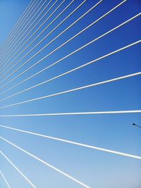 Low angle view of vapor trails against blue sky