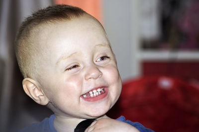 Close-up portrait of smiling boy at home