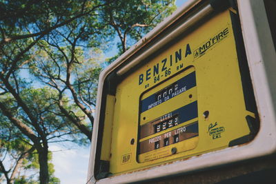 Low angle view of information sign board against trees