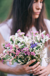 Midsection of woman holding flower bouquet