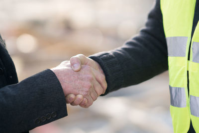 Cropped image of architects shaking hands at construction site