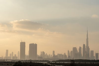 Modern buildings in city against cloudy sky