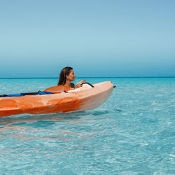 Young woman in sea against clear sky