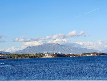 Scenic view of sea by buildings against sky