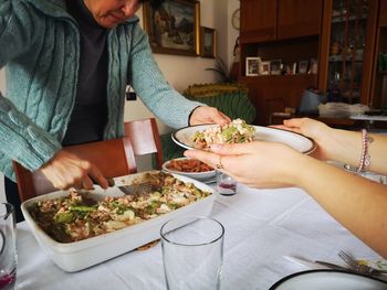 Midsection of woman serving food in home