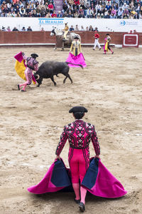 People with pink umbrella on land