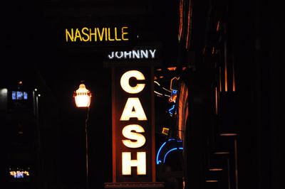 Illuminated sign on wall at night