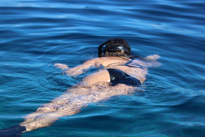 Rear view of woman swimming in sea