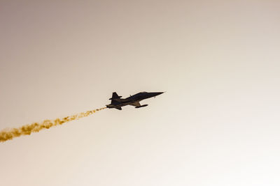 Low angle view of silhouette bird flying against clear sky