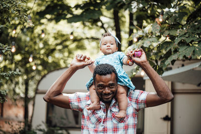 Portrait of father and son on tree against plants